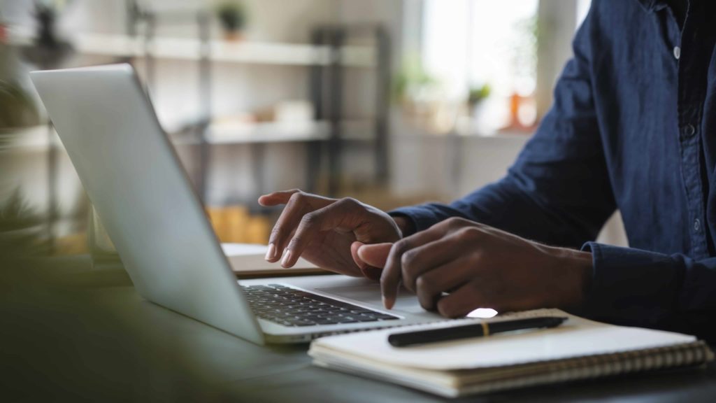 a photo of a man typing on a keyboard